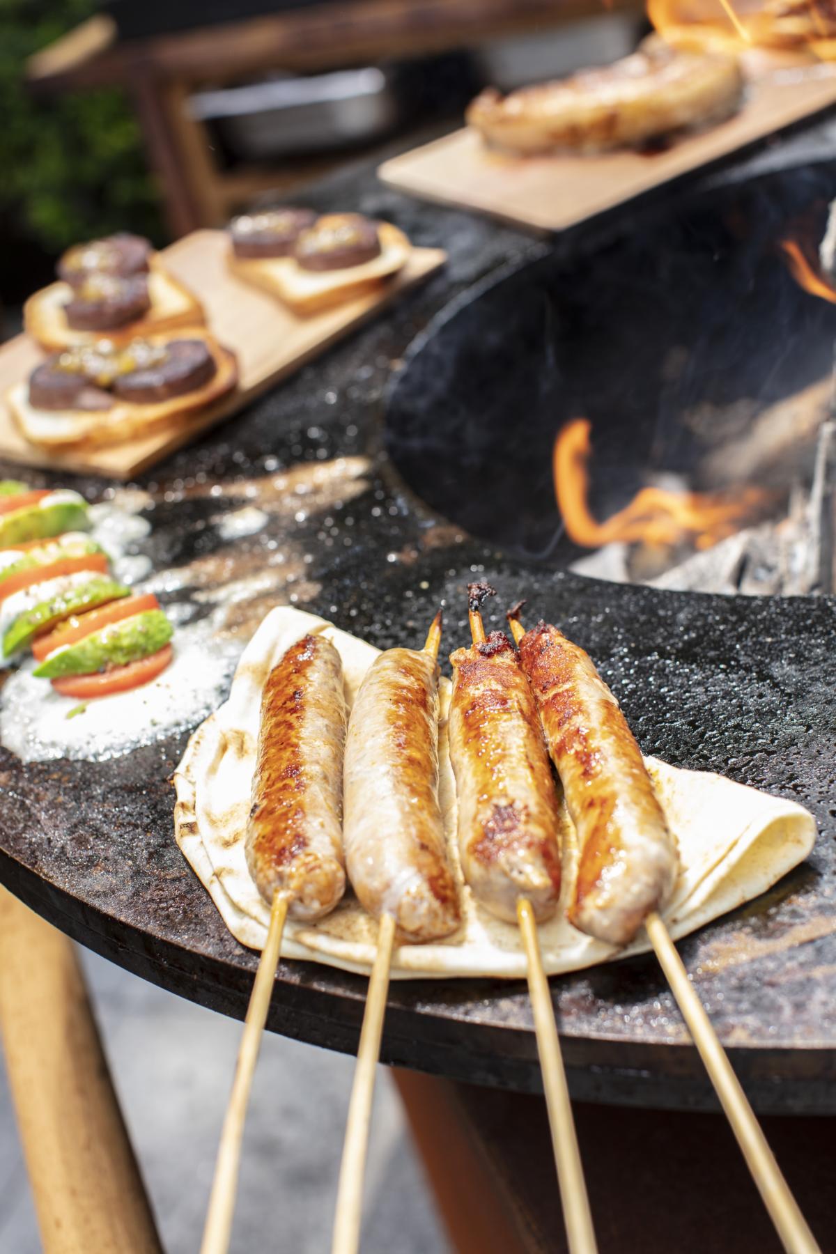 Ofyr Bratwurst am Spieß auf Grillfläche Plancha Ofyr Classic Corten 120 Pro+ 